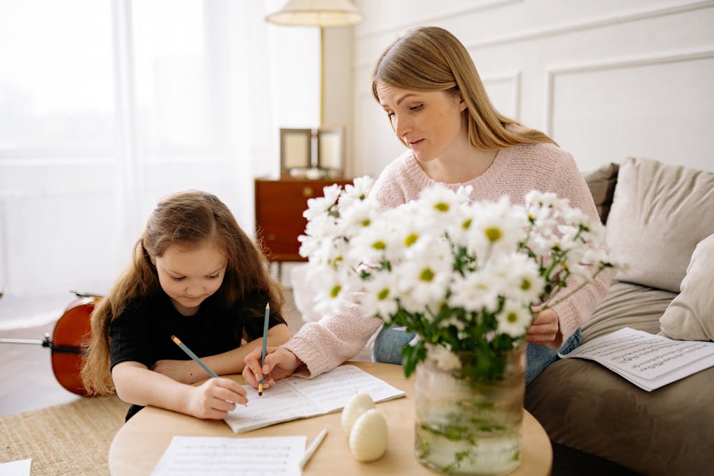 A mother helping her daughter read music notes at home, fostering education and creativity.