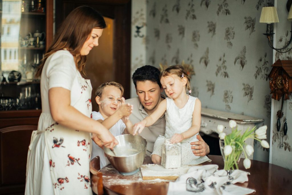Eine fröhliche Familie backt gemeinsam in einer gemütlichen Küchenatmosphäre und schafft so bleibende Erinnerungen.