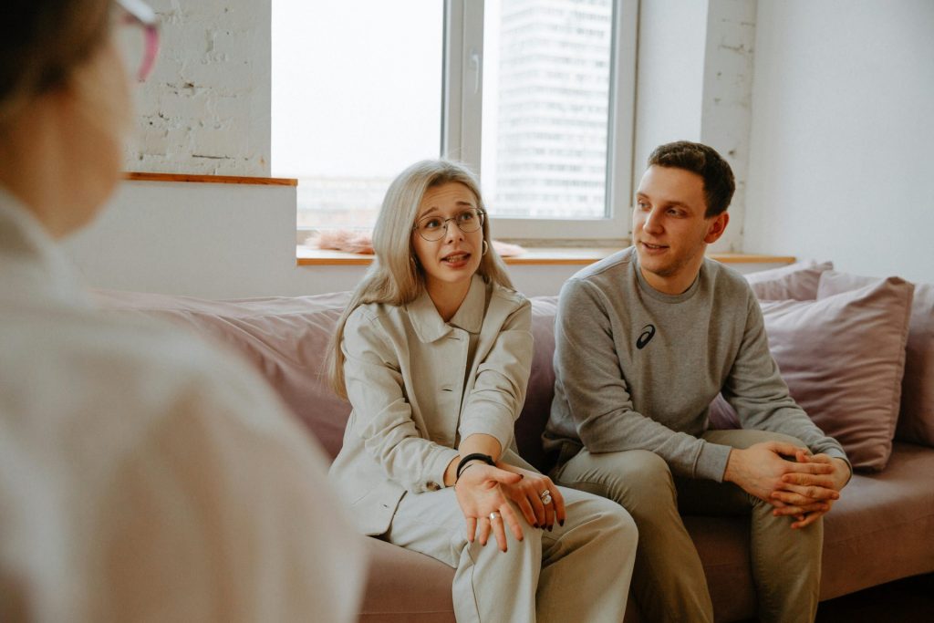 Ein Paar und sein Therapeut führten während einer Therapiesitzung in Innenräumen ein Gespräch.