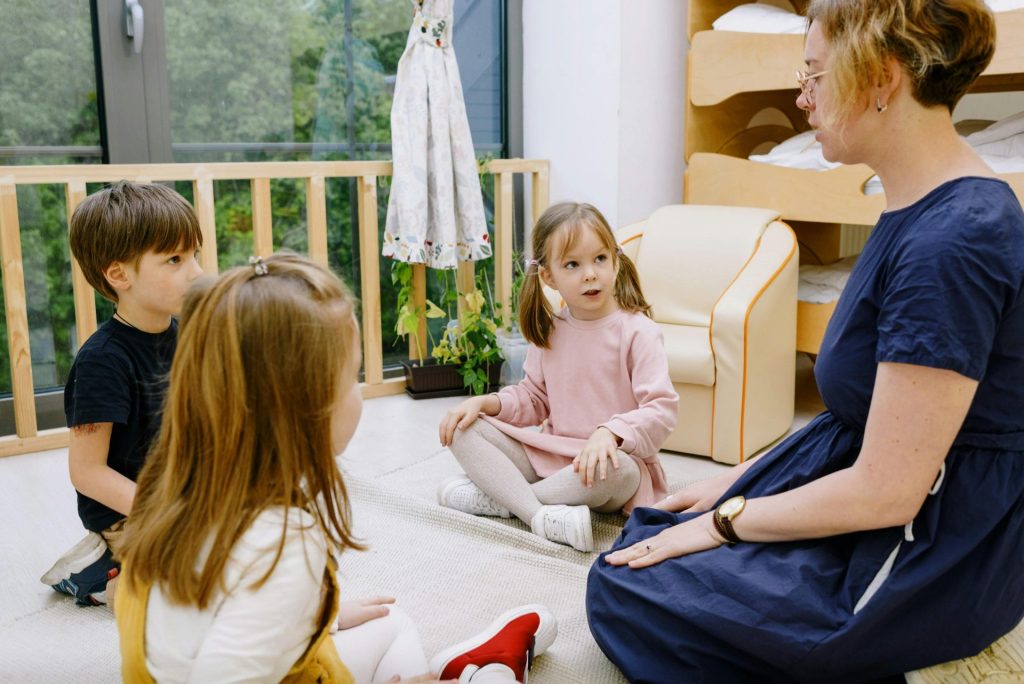 Eine Lehrerin interagiert mit Kindern in einer gemütlichen, lehrreichen Umgebung.