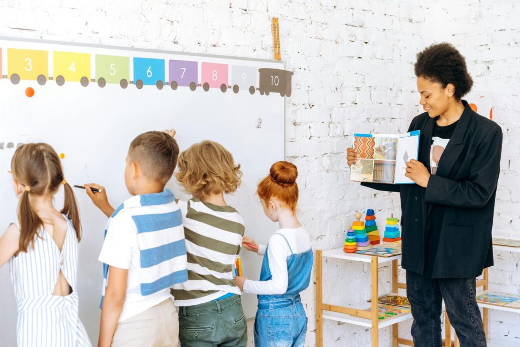 Kinder, die aktiv am Unterricht teilnehmen, während sie von einer Lehrkraft angeleitet werden.